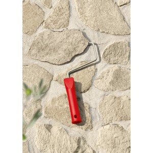 Farbroller mit rotem Griff vor einer mit Schöner Wohnen Trendfarbe Finca gestrichenen Wand.