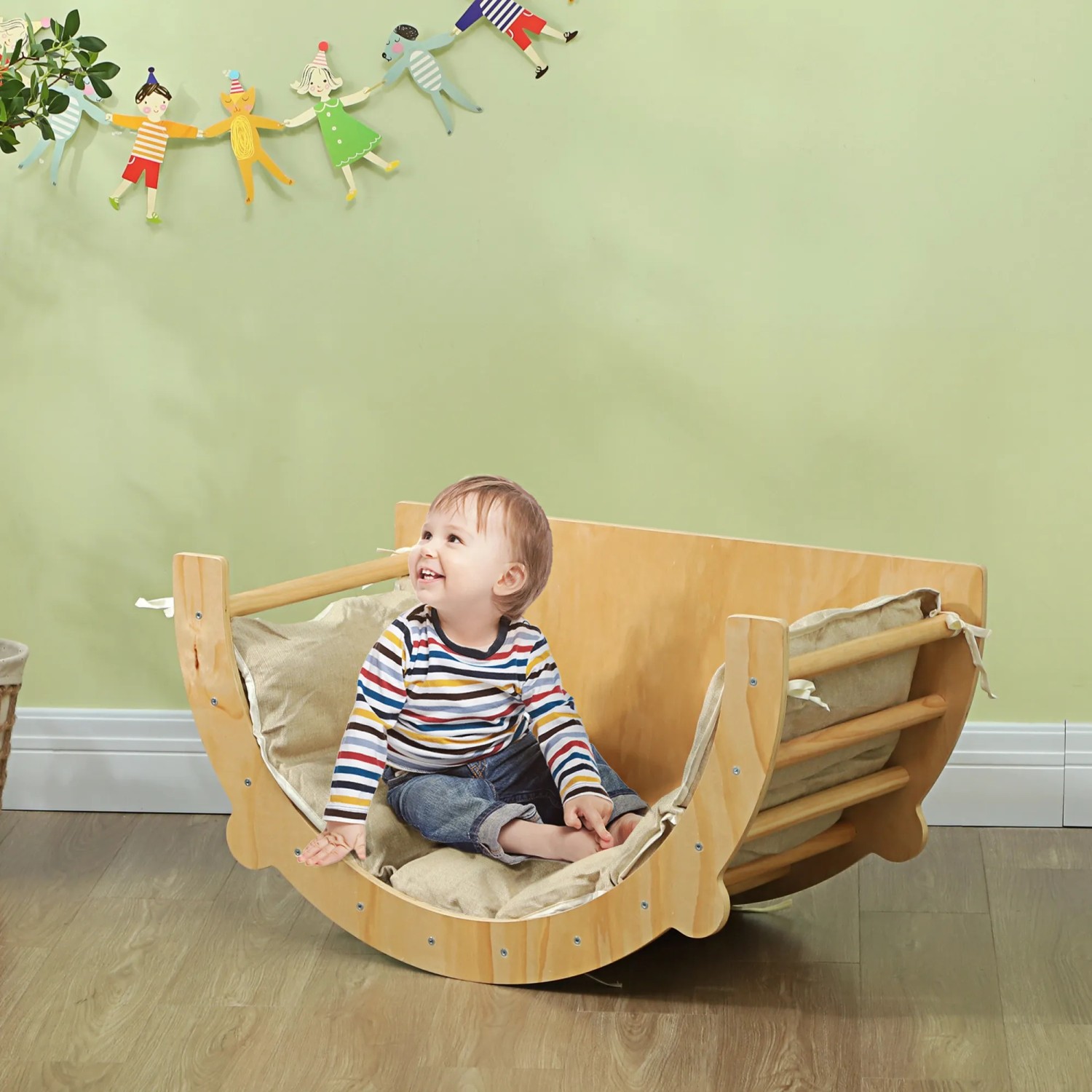 AIYAPLAY 3-in-1 Klettergerüst mit Kind im Naturholz-Design als Wippe mit Kissen.