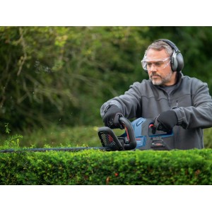 Mann schneidet Hecke mit Bosch Akku-Heckenschere GHE 18V-60(II).