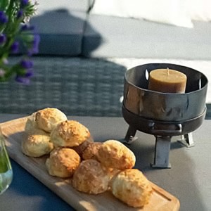 SIENA GARDEN Mini Feuerschale M aus Stahl mit Kerze und Gebäck auf Tisch.