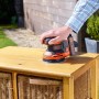 Black+Decker Akku-Exzenterschleifer BDCROS18 im Einsatz auf Holzmöbeln.