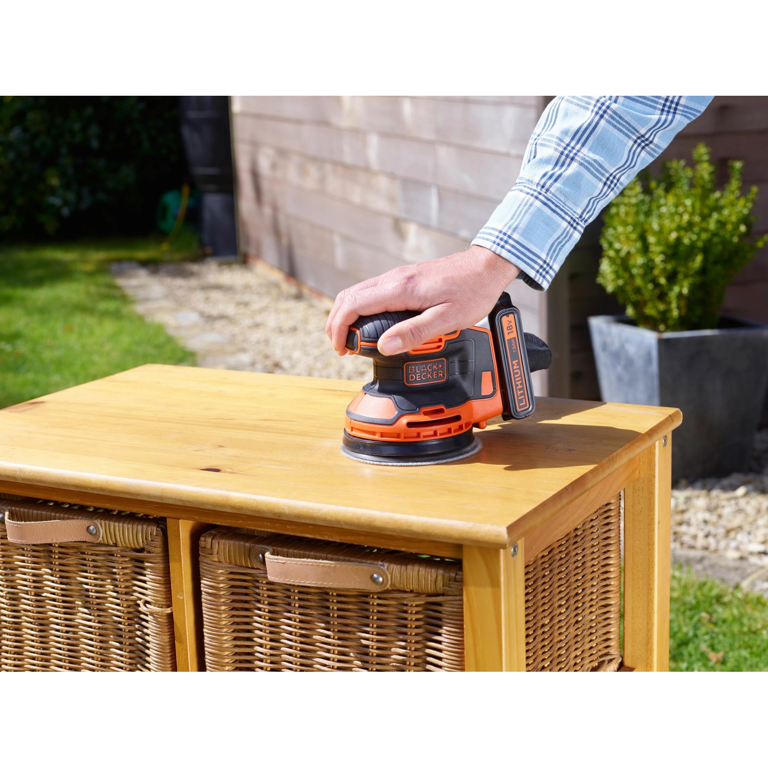 Black+Decker Akku-Exzenterschleifer BDCROS18 im Einsatz auf Holzmöbeln.