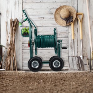 Grüner Metall-Gartenschlauchwagen mit Kurbel, 4 Rädern und aufgewickeltem Schlauch im Garten.