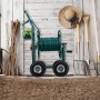 Grüner Metall-Gartenschlauchwagen mit Kurbel, 4 Rädern und aufgewickeltem Schlauch im Garten.