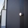 Moderne Lutec LED-Außenwandleuchte Eklips in Anthrazit mit drehbaren Leuchtenköpfen an einer Hauswand.