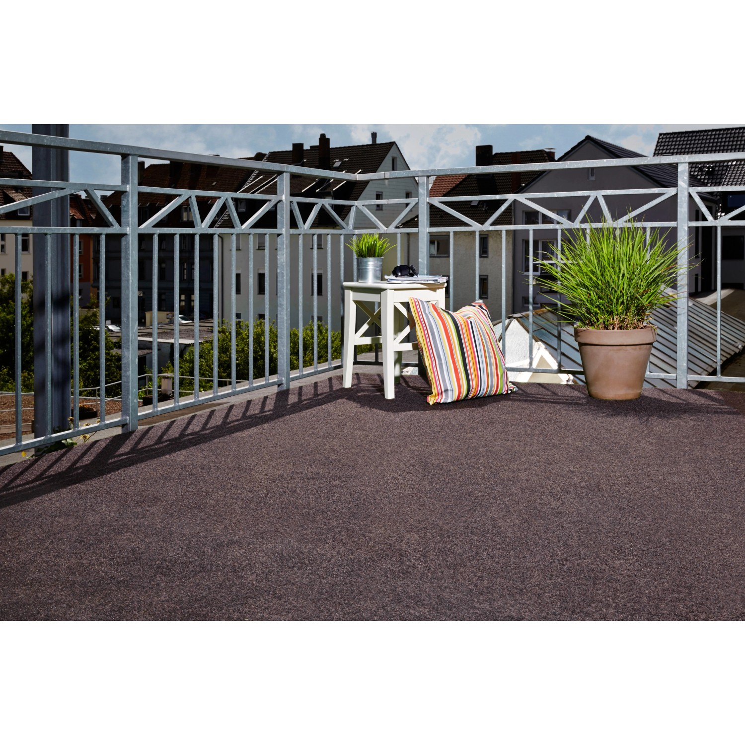 Braune Kunstrasen-Matte Field (400x200cm) auf einem Balkon mit Deko. Ideal für Terrasse und Garten.