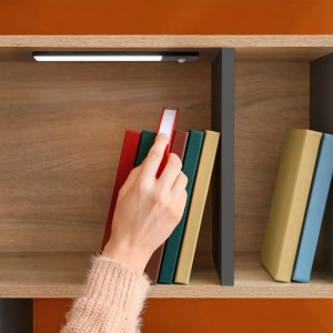Schwarze Emuca LED-Wandleuchte Kaus Black L400mm mit Bewegungssensor unter Holzregal, beleuchtet Bücher. USB wiederaufladbar.