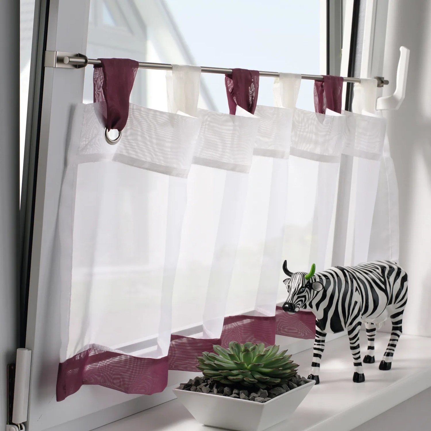 Gardinia Spannvitrage Titan (40-60cm) mit weißer Scheibengardine am Fenster.