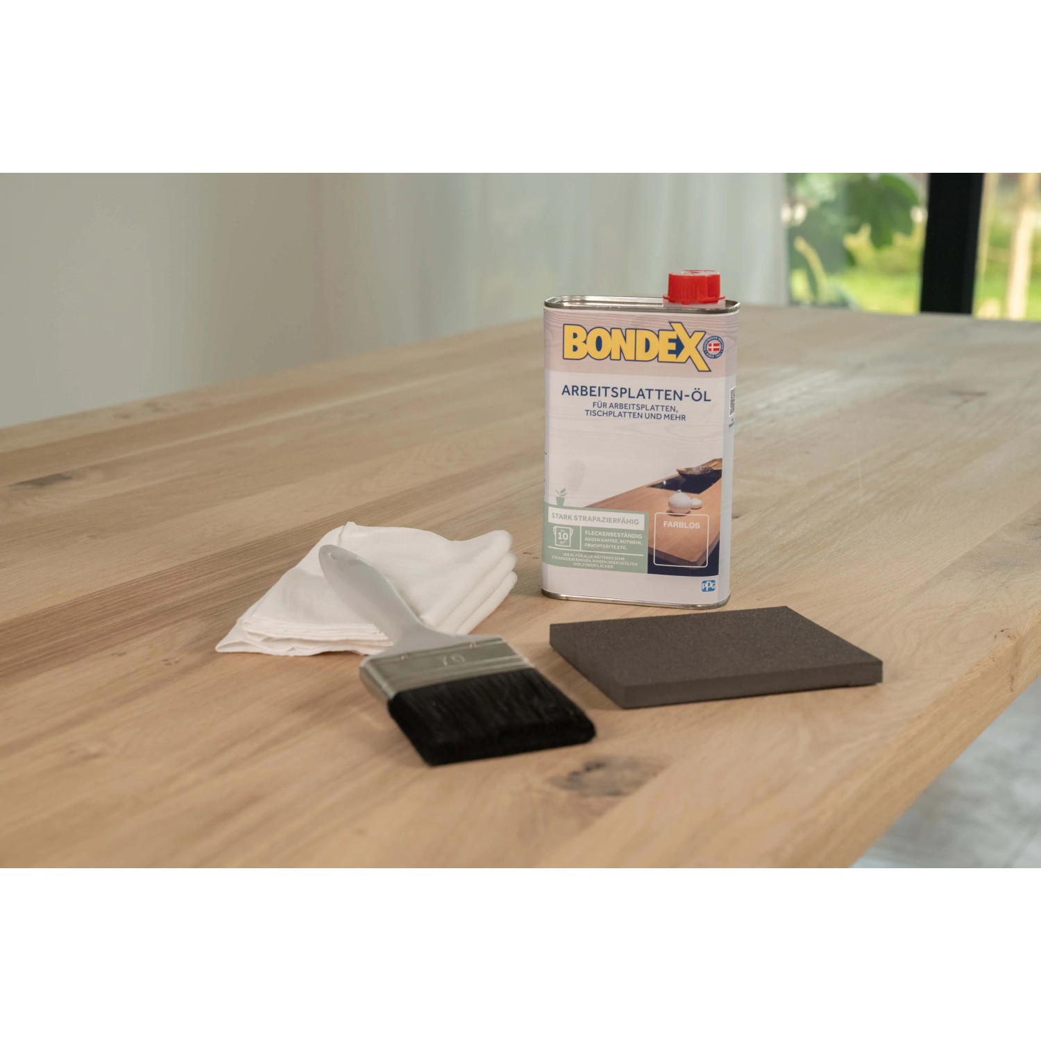 Bondex Arbeitsplatten-Öl transparent 500ml mit Pinsel, Tuch und Schleifpad auf Holzplatte.