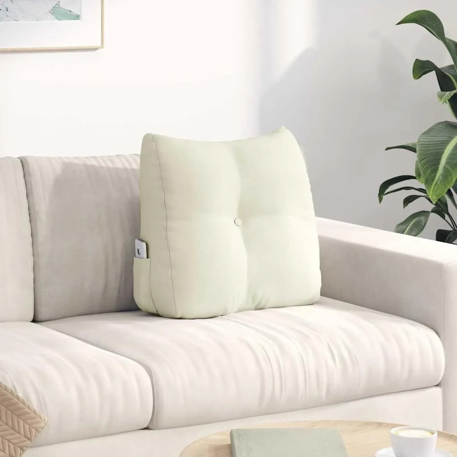 Cremefarbenes Samt-Rückenkissen auf Sofa, mit Knopfdesign und praktischer Seitentasche. Ideal für Komfort und Unterstützung.
