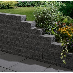 Graphitfarbene Montania Mauer aus Betonsteinen als Garteneinfassung mit Bepflanzung.