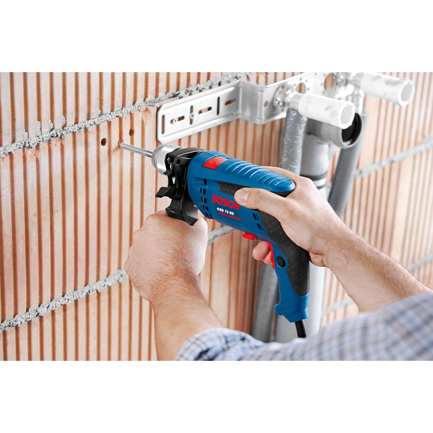 Bosch Professional GSB 13 RE Schlagbohrmaschine beim Bohren in eine Ziegelwand.