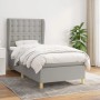 Helles, graues Boxspringbett 90x190 cm mit Matratze und Stoffbezug im Schlafzimmer.