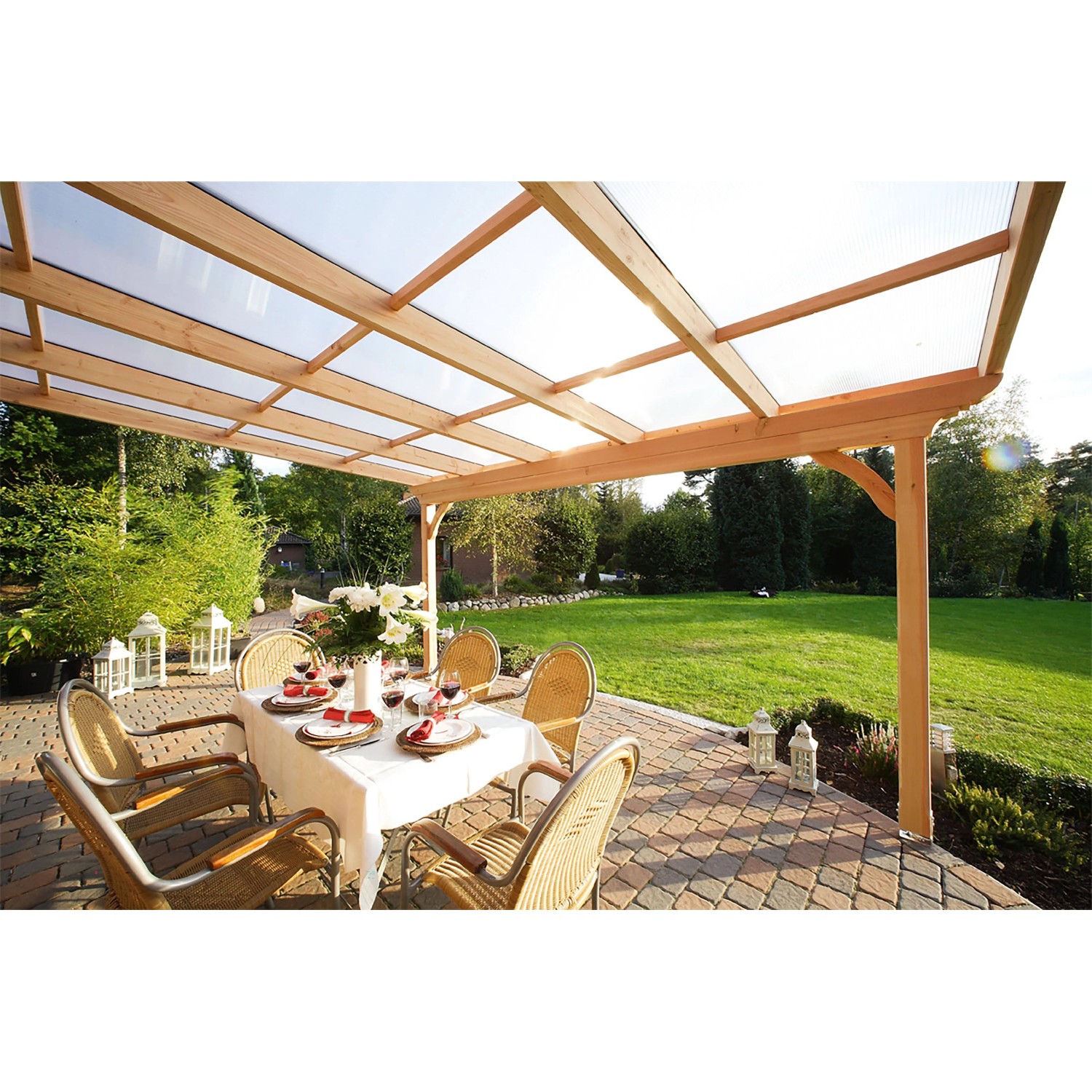 Skan Holz Terrassenüberdachung Ravenna aus Douglasie mit Polycarbonatplatten, darunter ein gedeckter Tisch.