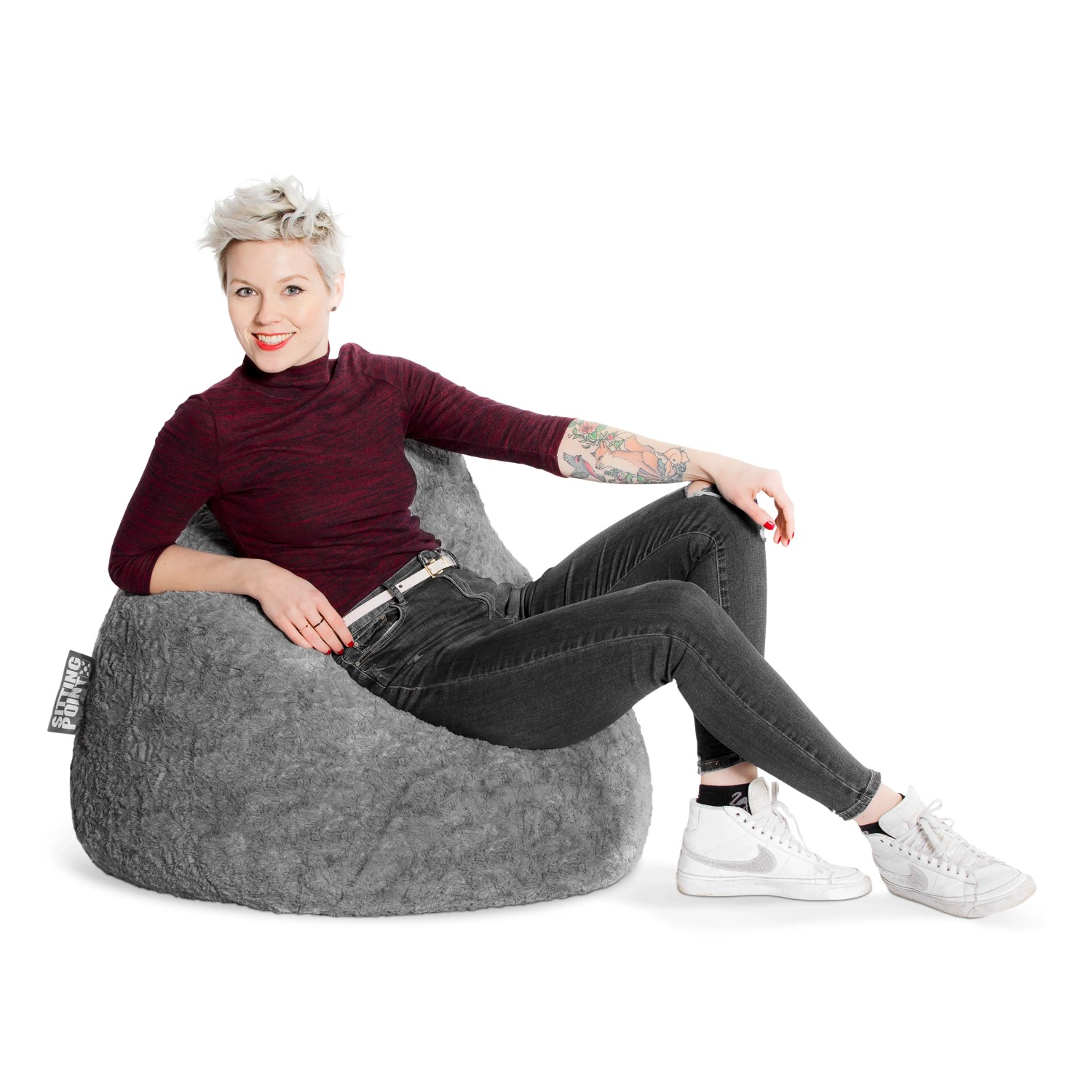 Frau sitzt entspannt im mittelgrauen Sitting Point Sitzsack Fluffy (220 l).