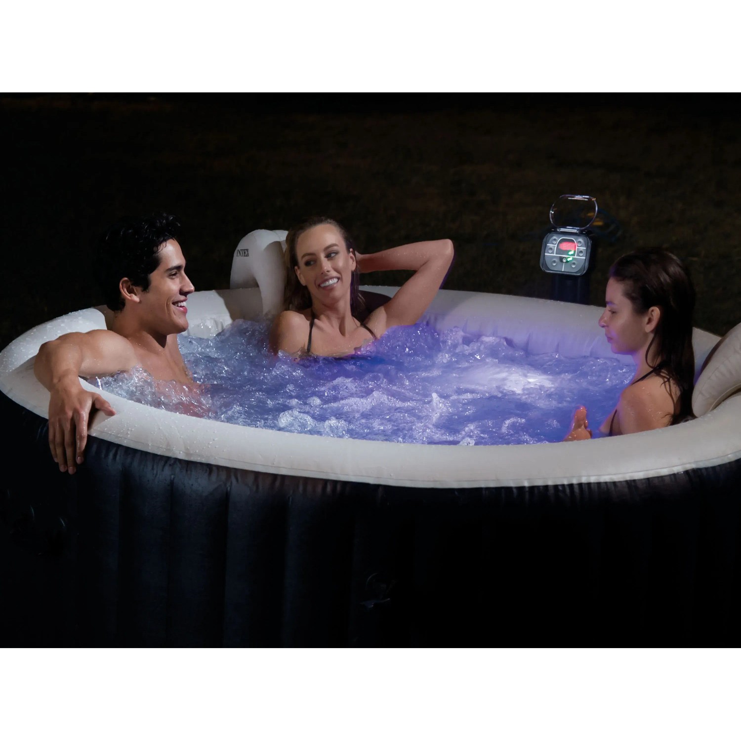 Intex PureSpa Bubble mit LED Beleuchtung und drei Personen im beleuchteten Pool.