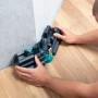 wolfcraft Schmiege und Gehrungsschneidlade im Einsatz: Mann misst präzise Winkel für Gehrungen an Wand und Holzboden.