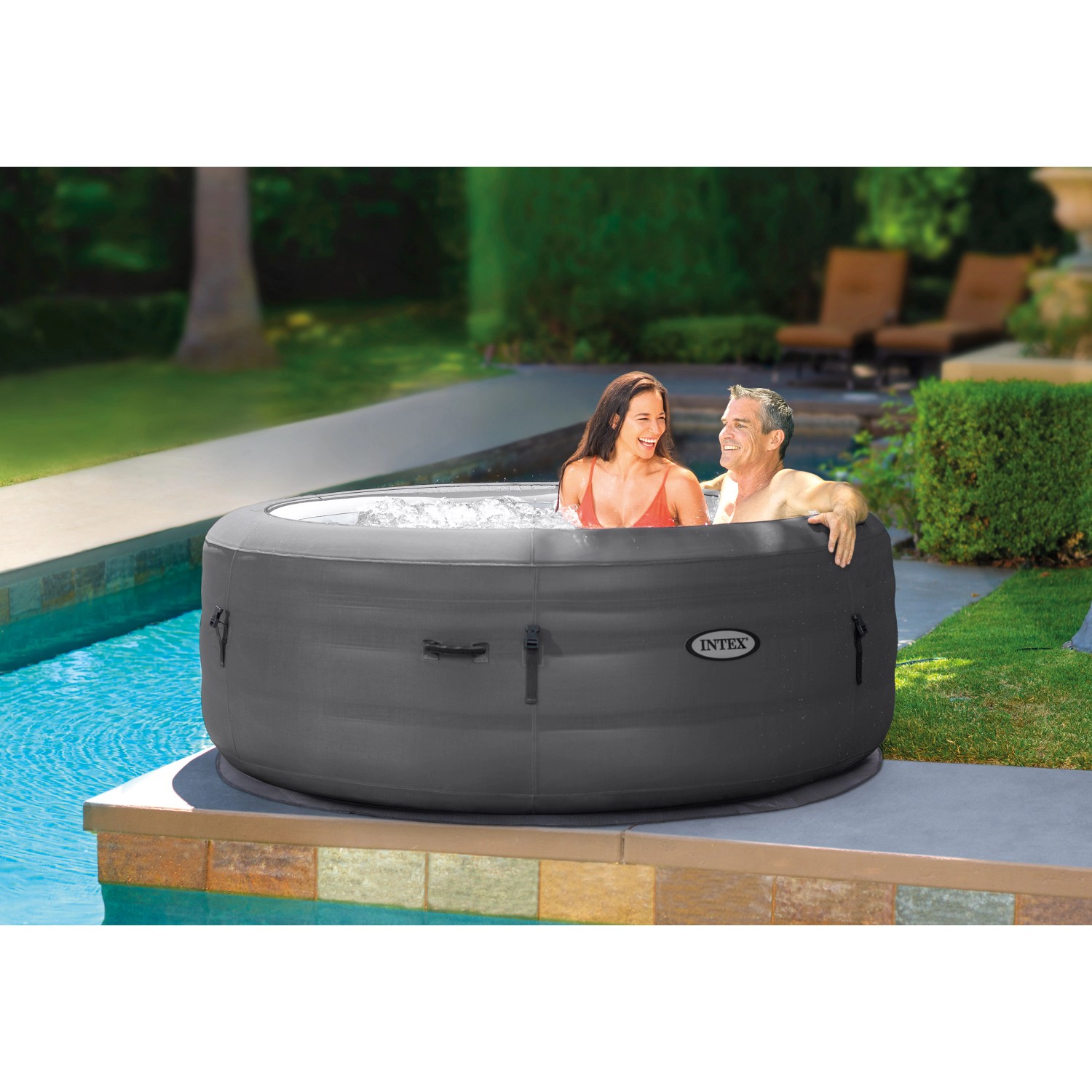 Intex SimpleSpa aufblasbarer Whirlpool (Ø 196 cm) mit zwei Personen im Garten.