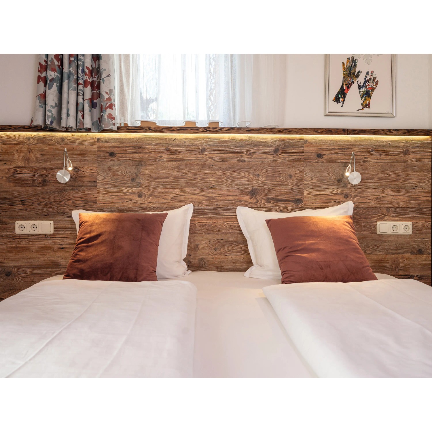Bett mit Egger DecoWall Wandpaneel Namur Fichte Natur als Kopfteil mit Lampen und Steckdosen.