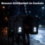 Schwarze Wiltec Doppel-Gepäckträgertasche am Fahrrad bei Nacht im Regen. Reflektierende Pfeile erhöhen die Sichtbarkeit.