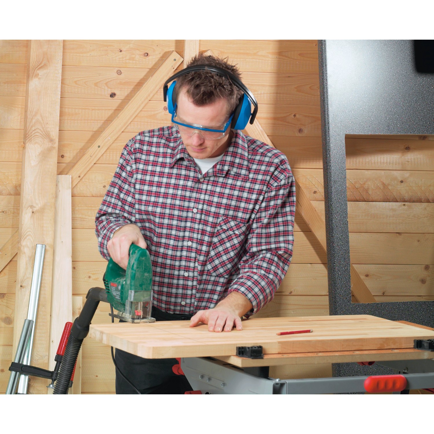 Mann mit blauem LUX Kapselgehörschutz beim Holzsägen für optimalen Gehörschutz.