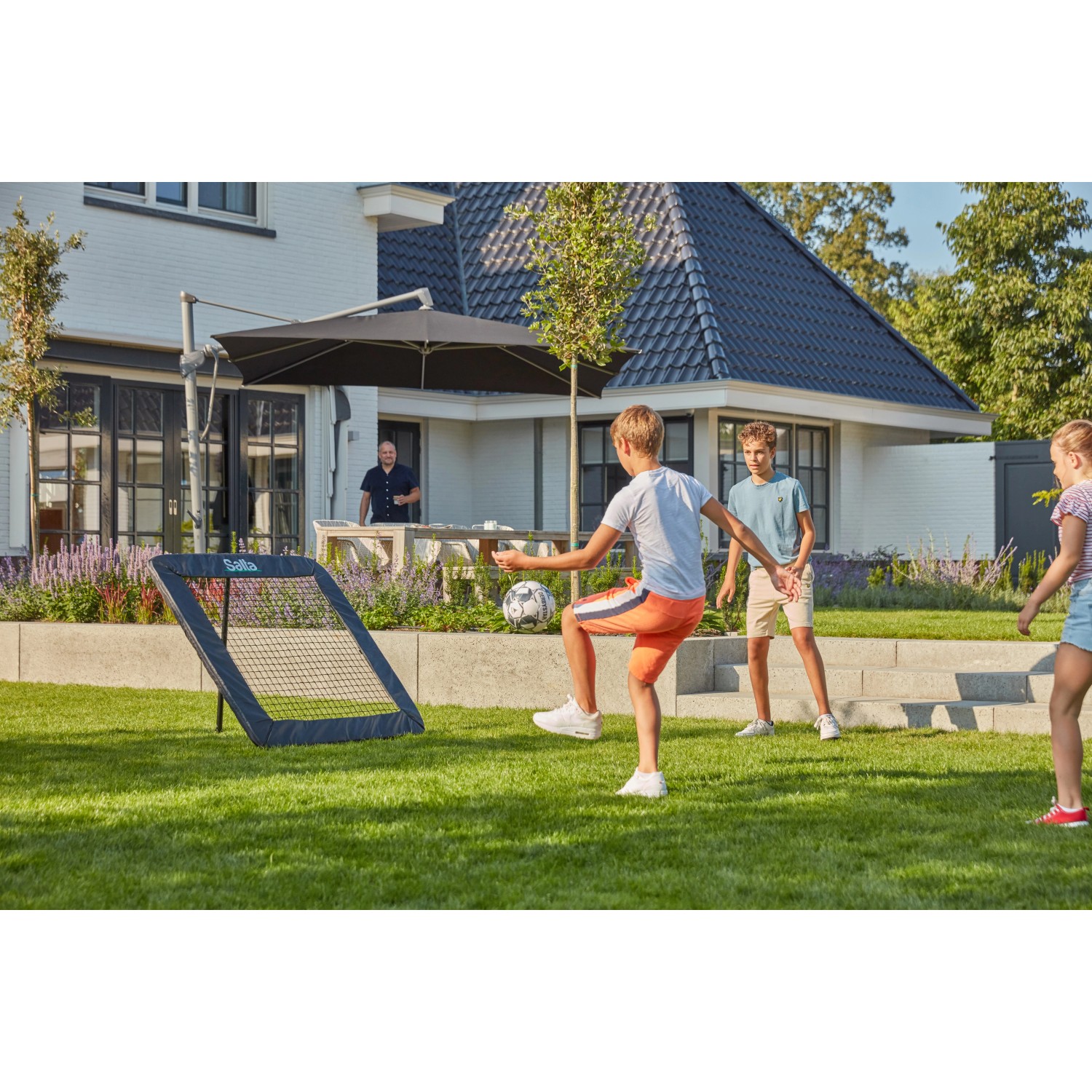 Salta Rückprallwand Motion: Kinder spielen Fußball mit dem Rebounder im Garten.