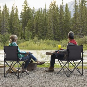 Zwei graue Sunula Campingstühle mit Personen am Flussufer, ideal für Camping und Outdoor.