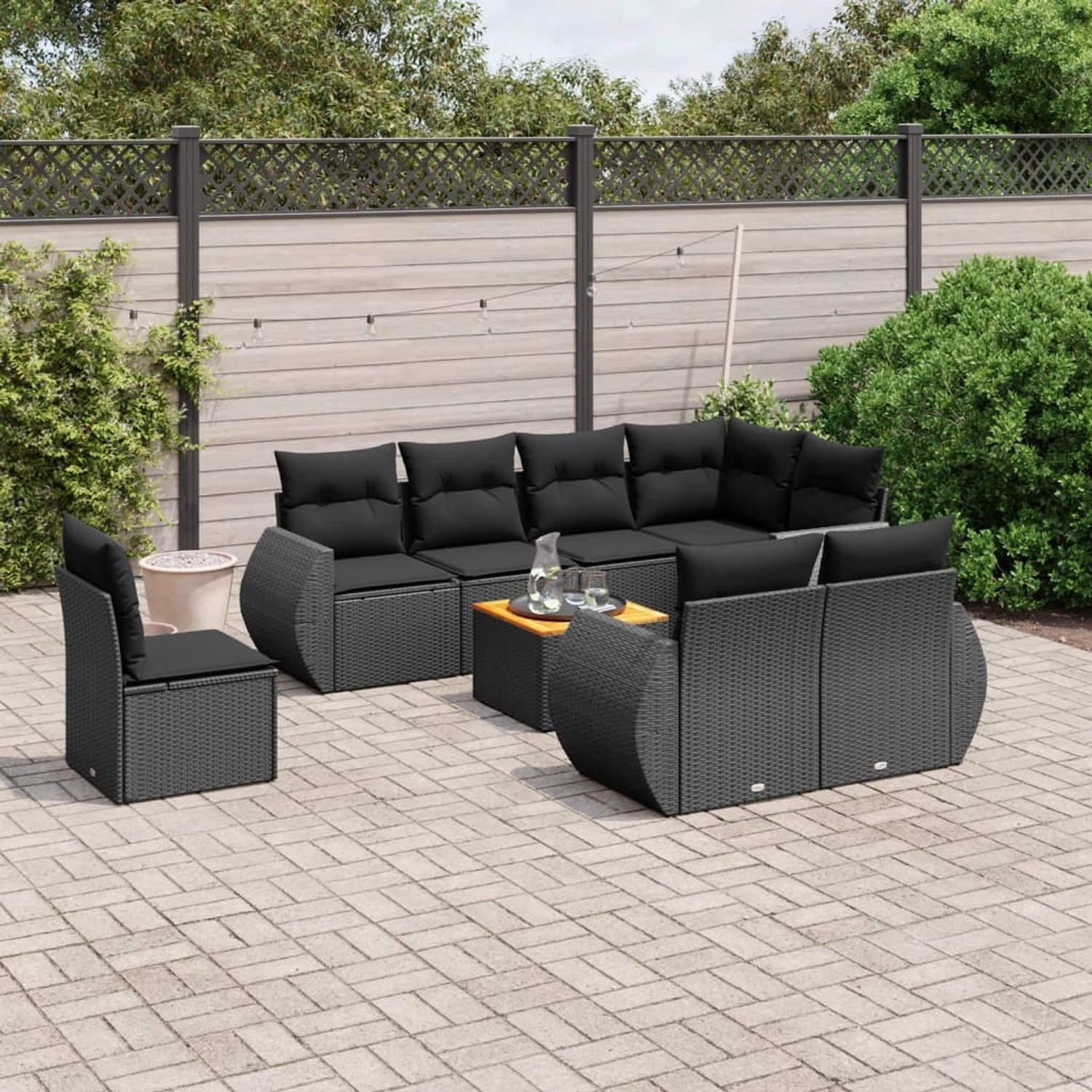 Schwarze 9-teilige Garten-Sofagarnitur aus Polyrattan mit Kissen und Tisch.