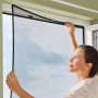 Frau montiert tesa® Insect Stop Anklips-Rahmen (anthrazit) am Fenster. Insektenschutz für Fenster.