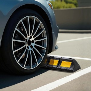 Robuster Gummi-Radstopper mit gelben Reflexstreifen vor einem Autoreifen. Einparkhilfe für Garage & Parkplatz.