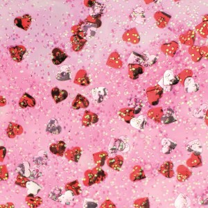 Glitzerkleber mit roten und silbernen Konfetti-Herzen auf rosa Hintergrund.