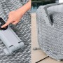Hand bedient das Bedienfeld des Bestway Bali AirJet Whirlpools in Rattan-Optik. App-Steuerung, Pumpe sichtbar.