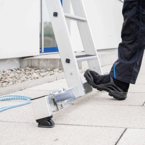 Detailaufnahme: Person steigt auf MUNK Seilzugleiter mit nivello® Traverse für sicheren Stand.