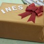 Geschenk mit roter Schleife und dem Namen "INES" aus weißen Relaxdays Holz Buchstaben.