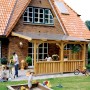 Skan Holz Deckelschalung Brüstung aus Douglasie an Terrassenüberdachung mit spielenden Kindern im Garten.