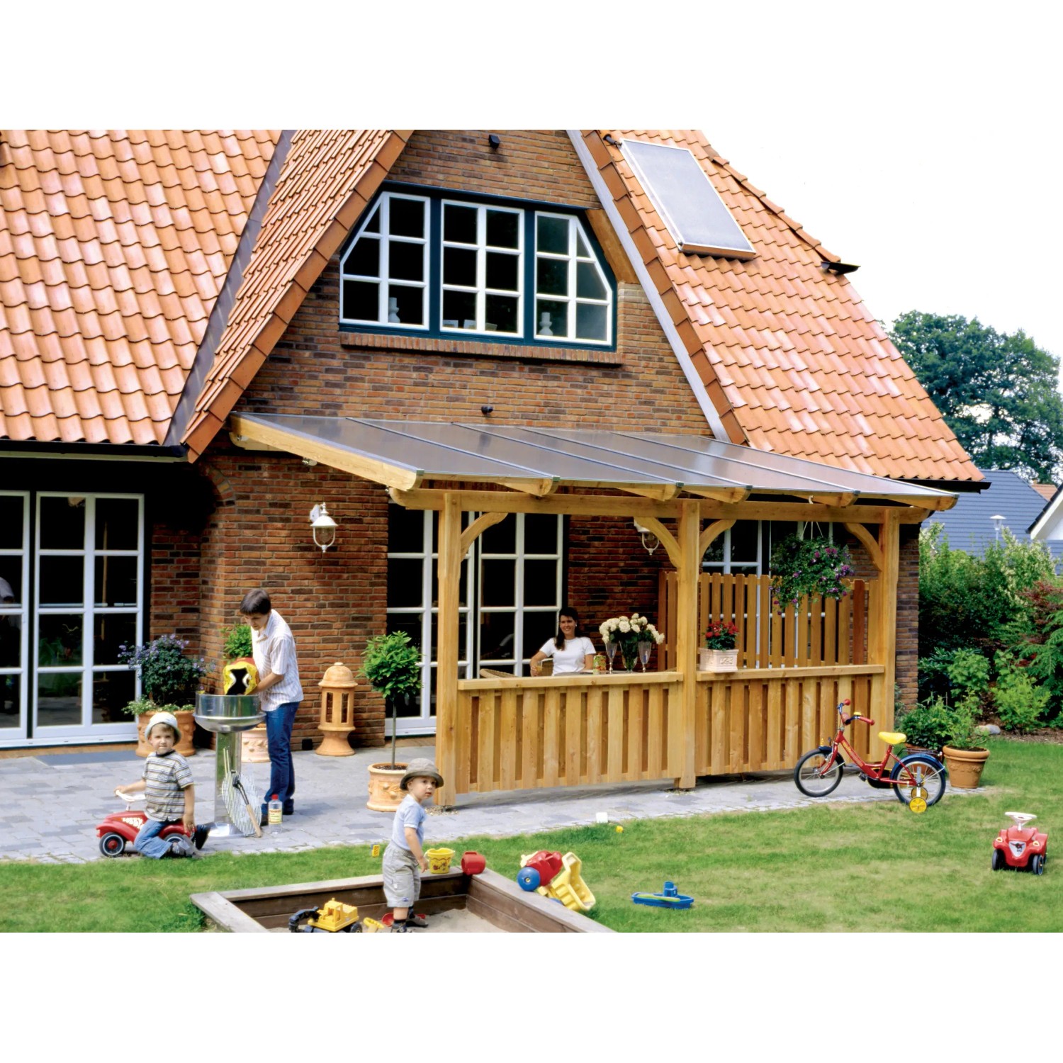 Skan Holz Deckelschalung Brüstung aus Douglasie an Terrassenüberdachung mit spielenden Kindern im Garten.