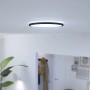 Schwarze WiZ LED-Deckenleuchte SuperSlim, dimmbar, Ø 29,2 cm, montiert an einer weißen Decke.