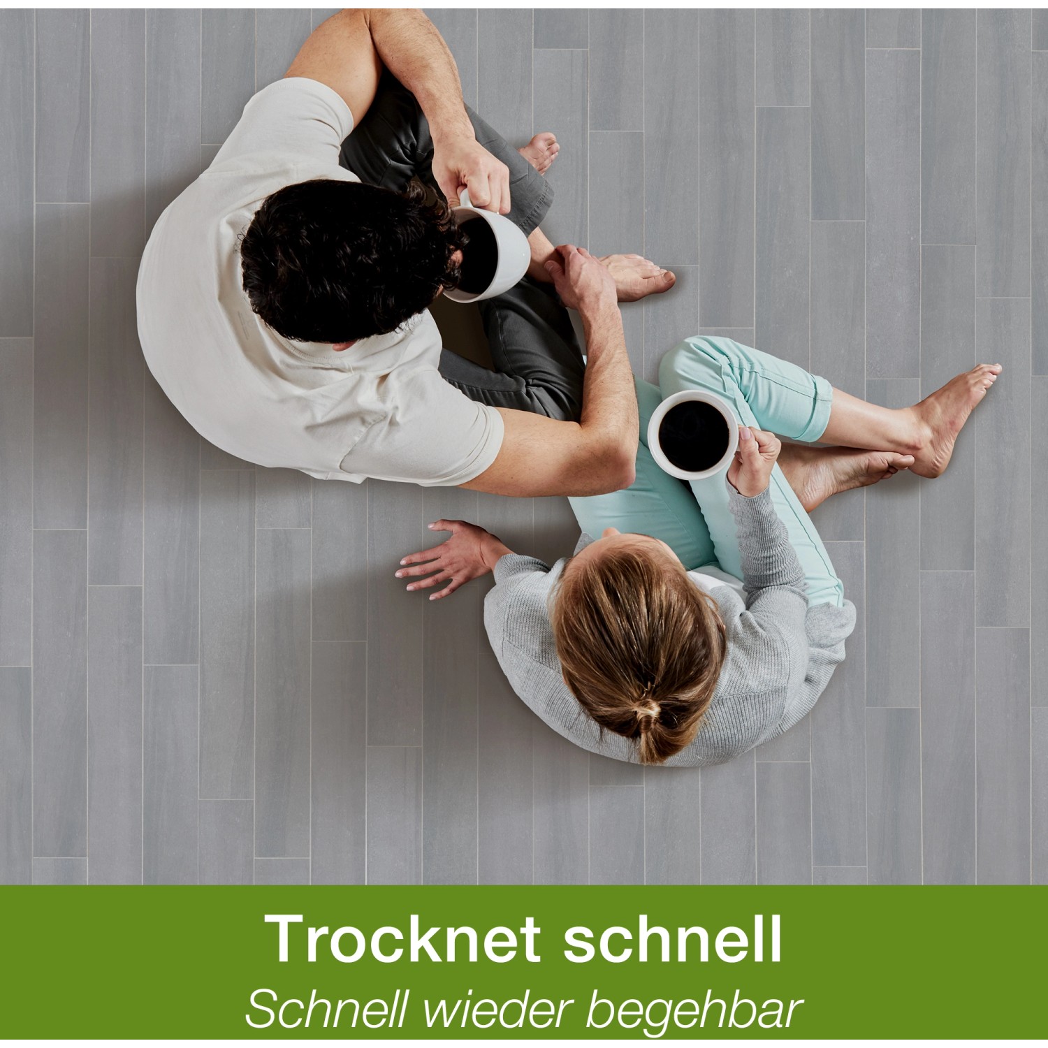 Paar sitzt auf gereinigtem Steinboden mit Tassen. Bona Reiniger für Fliesen, Laminat für schnelle Trocknung.