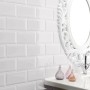 Glänzende, weiße Wandfliese Facette Metro im Badezimmer mit Waschbecken und Spiegel.