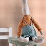 ESTAhome Vliestapete mit orangefarbenem Karomuster an einer Wand, davor ein Stoffhase auf einem Tisch. Dekorative Tapete.