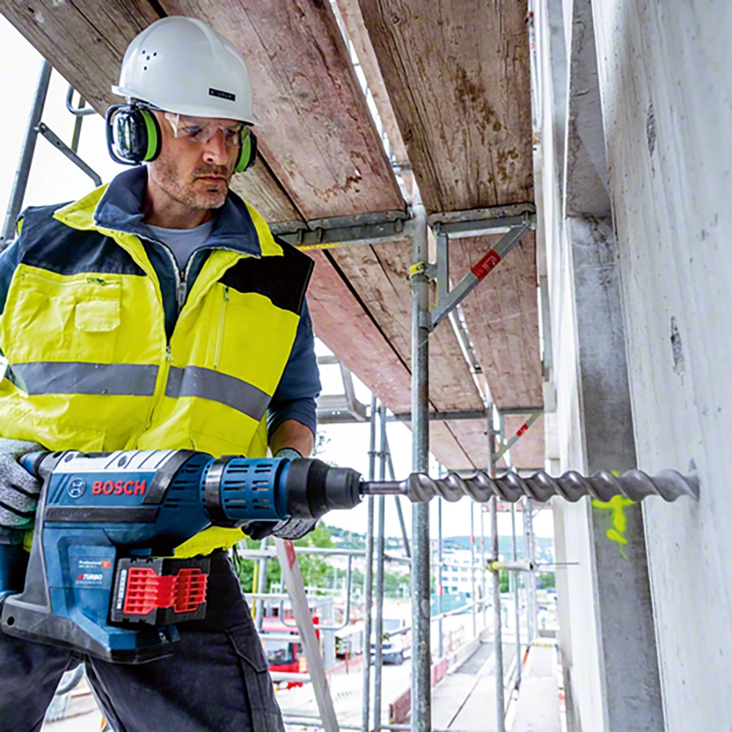 Handwerker bohrt mit dem Bosch Professional Akku-Bohrhammer GBH 18V-45 C ein Loch in eine Betonwand.