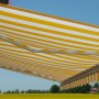 MCW Kassettenmarkise H123, 4,5x3m, gelb/weiß gestreift mit Volant, ausgefahren vor gelbem Feld.