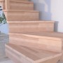 Gewendelte Buchenholztreppe Lindos mit Setzstufen und Holz-Edelstahl-Geländer, 100 cm breit.