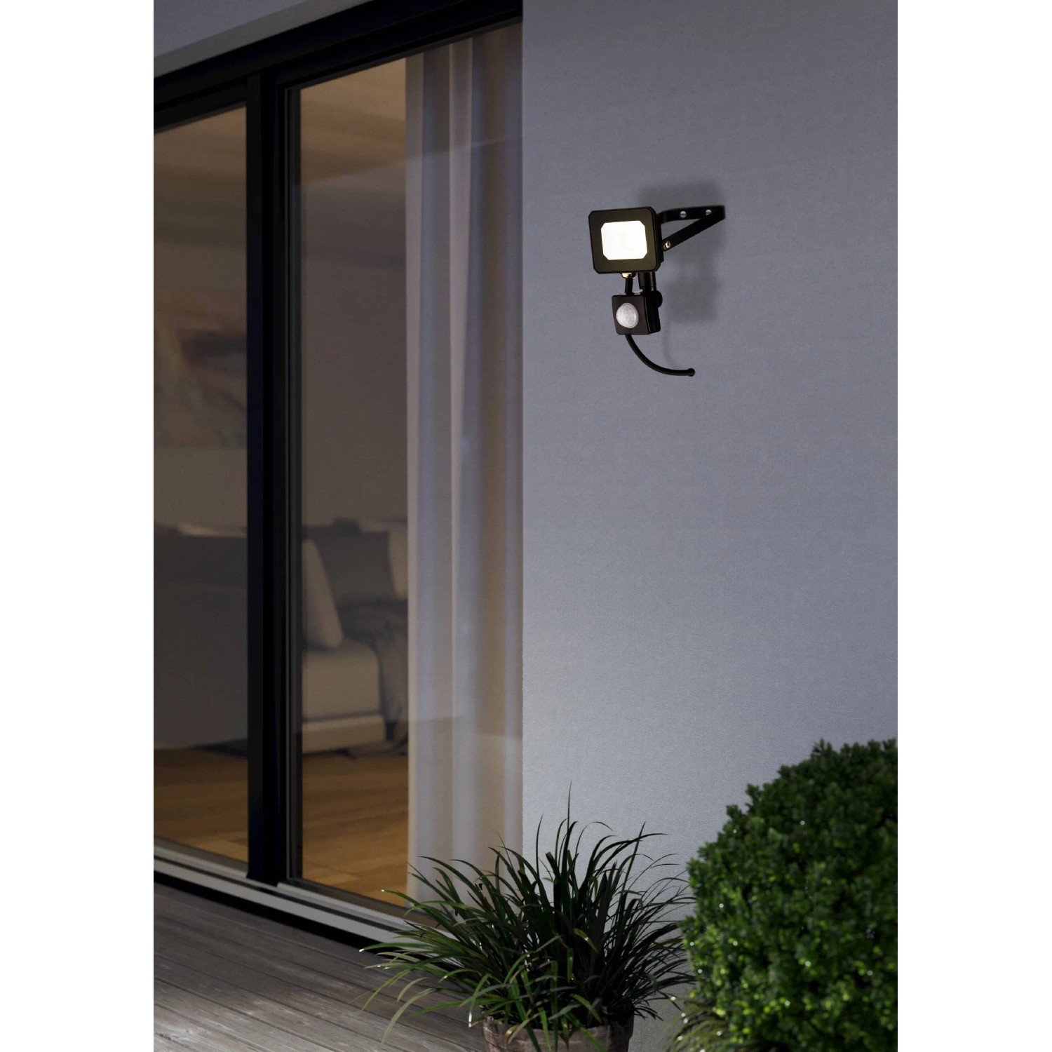 Schwarzer Eglo LED-Wandstrahler Risacca-E mit Sensor an einer Hauswand.