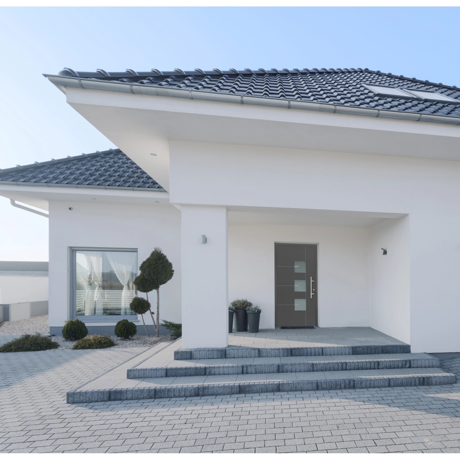 Moderne anthrazitfarbene Aluminium Sicherheitshaustür Moderno RC3 mit Glaseinsätzen am Hauseingang.