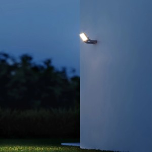Weißer Steinel XLED One S Sensor-LED-Strahler an Hauswand im Garten.