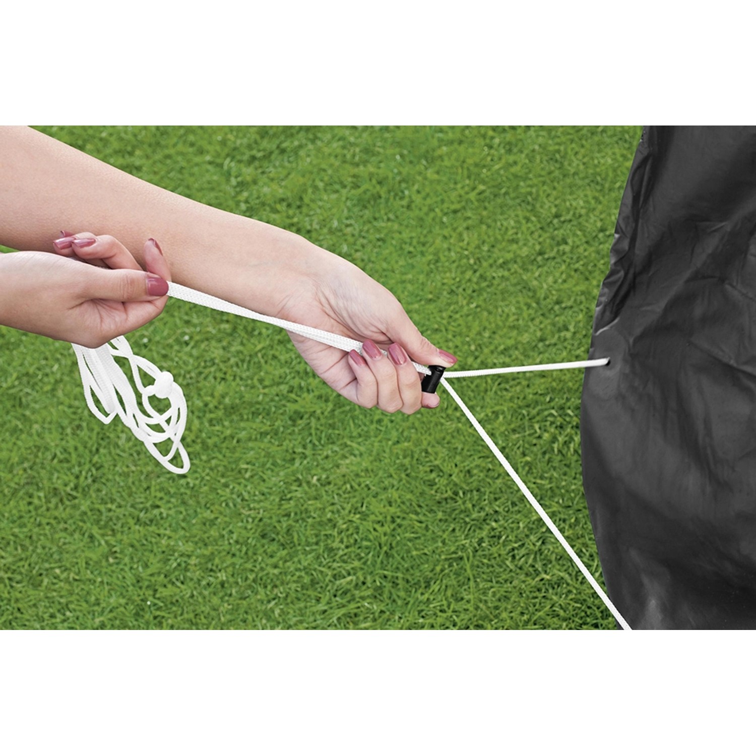 Graue Flowclear Pool Abdeckplane (427x427 cm) wird mit Seil auf einem Pool befestigt.