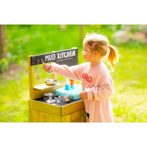 Mädchen spielt mit TP Toys Deluxe Kinderspielküche aus Holz mit Waschbecken im Garten.