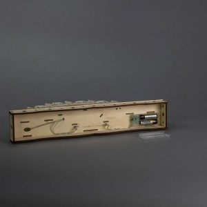 Rückseite der Konstsmide Holzsilhouette Winterdorf. Batteriefach mit 2 AA-Batterien und LED-Verkabelung sichtbar.