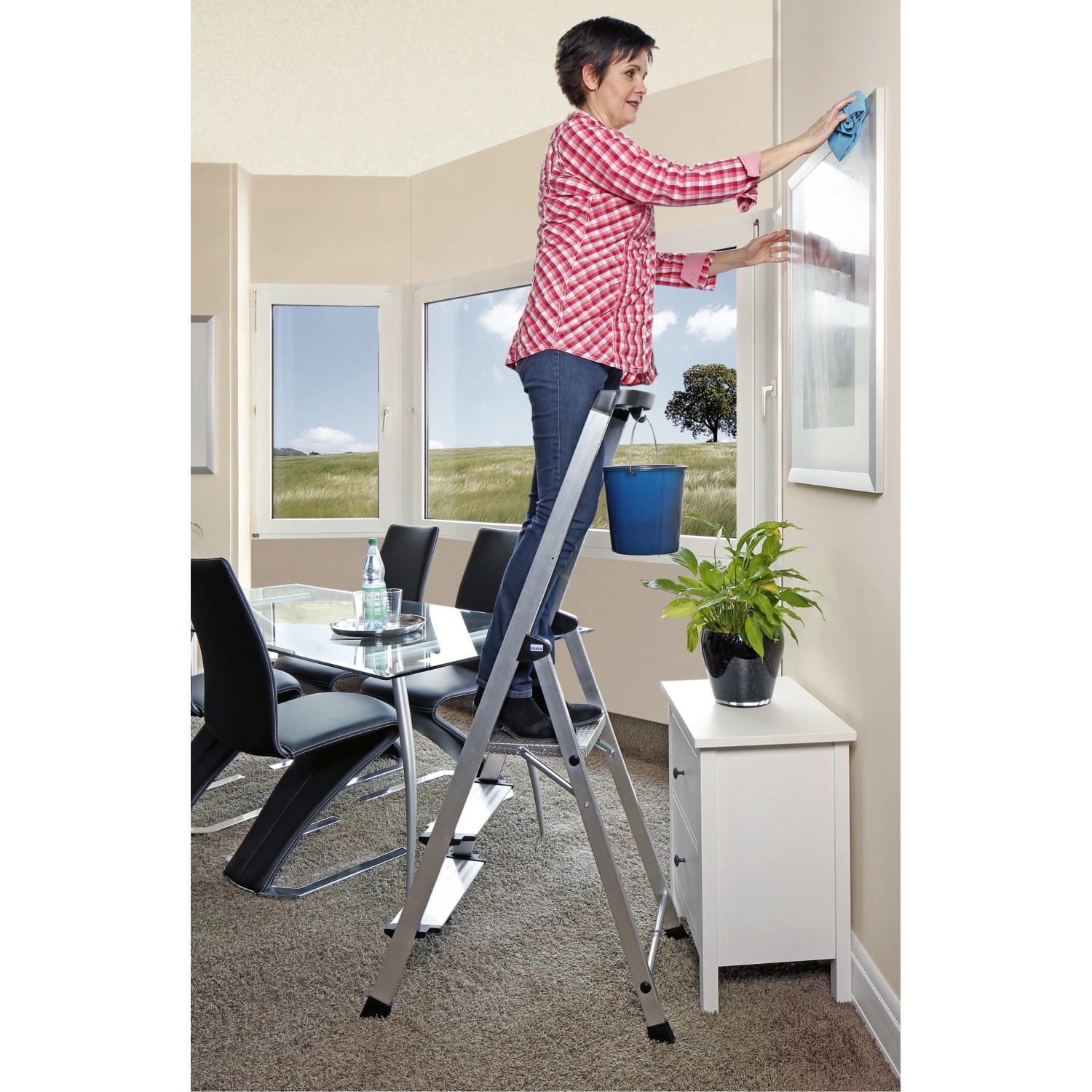Krause Stehleiter Safety Plusline mit 3 Stufen im Einsatz beim Fensterputzen.